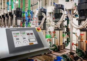Industrial automation control panel with PLC system monitoring pumps and machinery