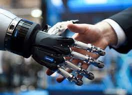 Human hand shaking hands with a robotic hand symbolizing Industry 5.0 collaboration.