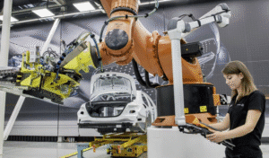 Female engineer operating robotic arm in an automotive CNC manufacturing environment