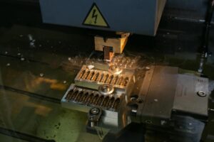 Electrochemical milling machine processing metal workpiece with precision sparks & fluid flow for detailed component shaping