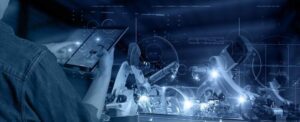 Engineer controlling robotic arms via tablet, showcasing automation and AI in modern Lathe Works Technology.