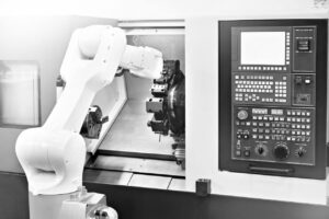 Robotic arm operating a CNC lathe machine, showcasing advanced automation in modern lathe works technology.